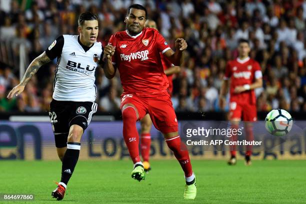 Valencia's forward Santi Mina challenges Sevilla's Argentinian defender Gabriel Mercado during the Spanish league football match Valencia CF vs...