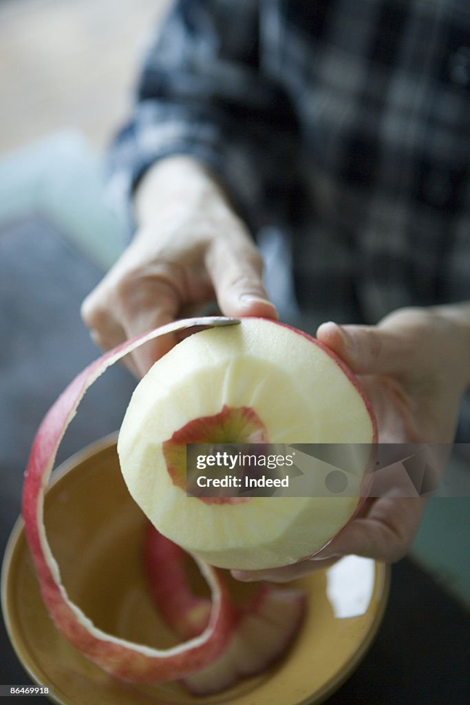 Mature woman peeling apple skin