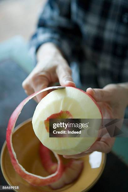 mature woman peeling apple skin - éplucher photos et images de collection
