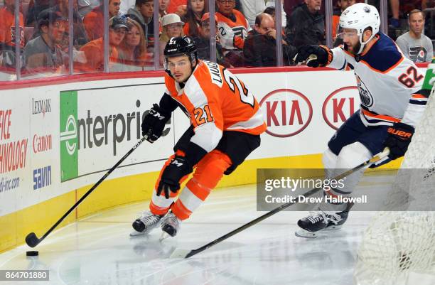 Scott Laughton of the Philadelphia Flyers comes around the goal with Eric Gryba of the Edmonton Oilers defending at the Wells Fargo Center on October...