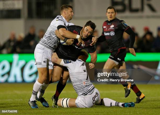 Brad Barritt of Saracens tackled by Dan Biggar of Ospreys and Justin Tipuric of Ospreys during the European Rugby Champions Cup match between...