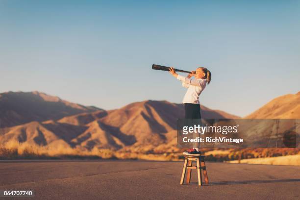 jonge business meisje kijkt door telescoop - see stockfoto's en -beelden