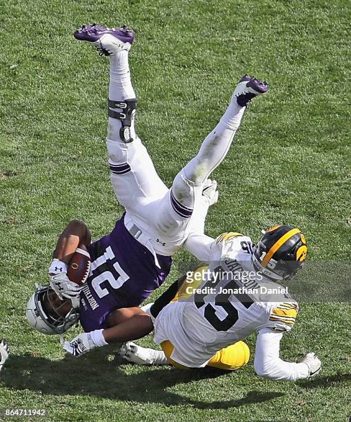 Justin Jackson of the Northwestern Wildcats is upended by Joshua Jackson of the Iowa Hawkeyes at Ryan Field on October 21, 2017 in Evanston,...