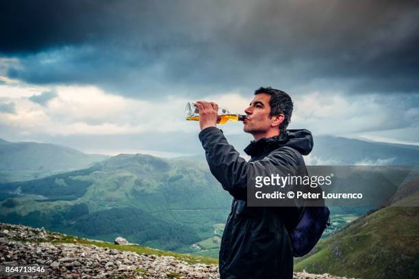 drinking scotch from the bottle on ben nevis - peter lourenco fotografías e imágenes de stock