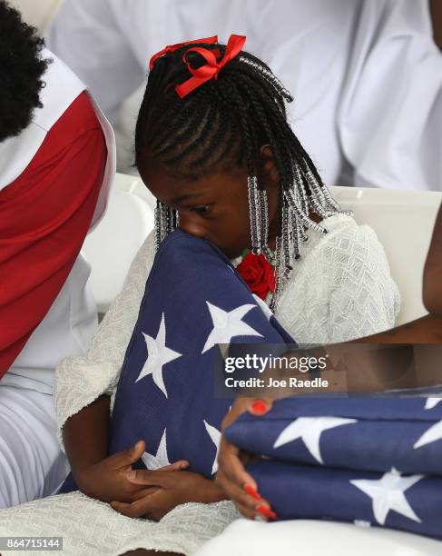 Ah'Leesya Johnson holds a folded American flag given to her during the burial service for her father U.S. Army Sgt. La David Johnson at the Memorial...