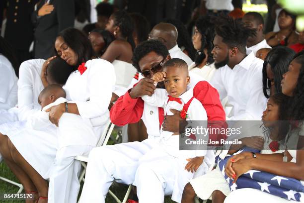 Richard Johnson, Sr. Holds the hand of La David Johnson jr. To his forehead for a salute during the burial service for his father U.S. Army Sgt. La...