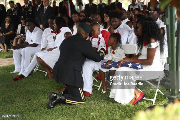 La David Johnson, Jr. Is given an American flag by a military honor guard member during the burial service for his father U.S. Army Sgt. La David...