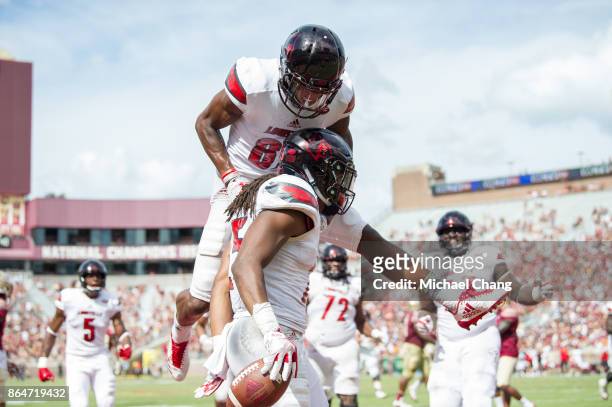 Running back Dae Williams of the Louisville Cardinals celebrates with wide receiver Dez Fitzpatrick of the Louisville Cardinals after scoring a...
