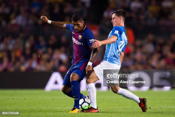 Paulinho of FC Barcelona fights for the ball with Juanpi of Malaga CF during the La Liga match between Barcelona and Malaga at Camp Nou on October...