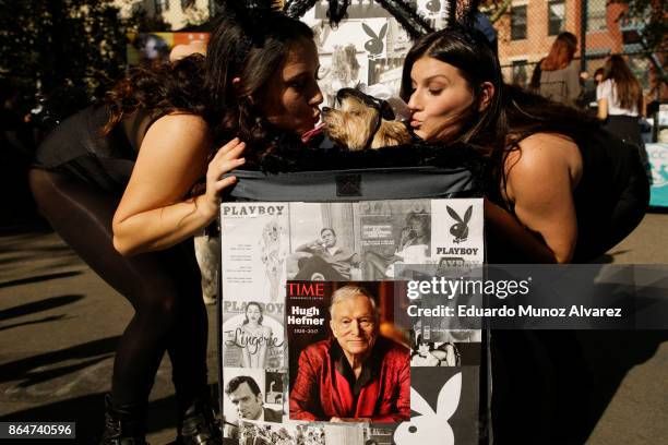 Dog in costume of playboy is kissed by its owners as they attend the 27th Annual Tompkins Square Halloween Dog Parade in Tompkins Square Park on...