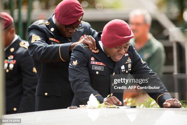 Members of the 3rd Special Forces Group, 2nd battalion, comfort each other as they say their las goodbyes to US Army Sgt. La David Johnson at the...