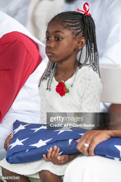 Ah'Leesya Johnson holds a folded US flag given to her during the burial service for her father US Army Sgt. La David Johnson at the Memorial Gardens...