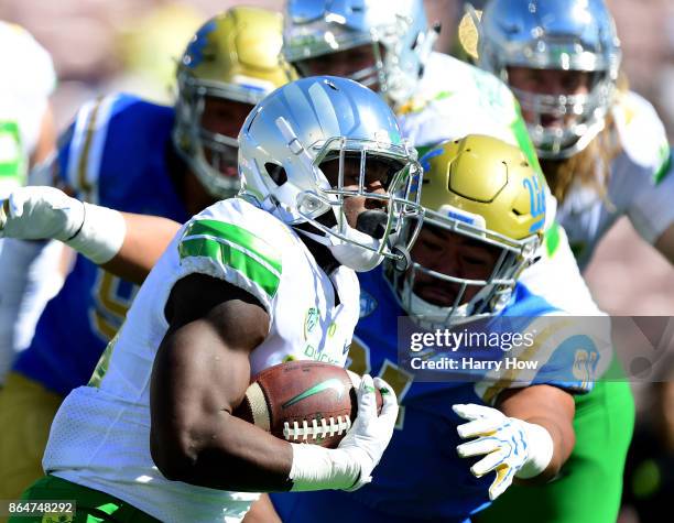 Royce Freeman of the Oregon Ducks runs as he is pursued by Jacob Tuioti-Mariner of the UCLA Bruins during the first half at Rose Bowl on October 21,...