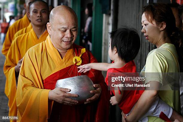 Buddhist monks receive religious meals from Buddhist members of the public as they walk around the streets on Vesak Day, commonly known as 'Buddha's...