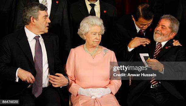 Queen Elizabeth II sits with Britain's Prime Minister Gordon Brown, left, and Brazil's President Luiz Inacio Lula da Silva, right, who talks to...