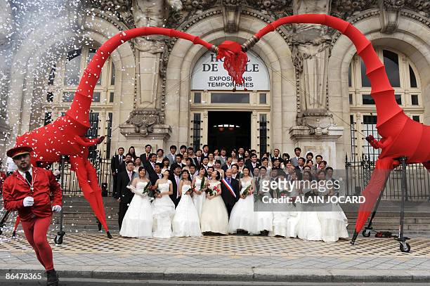 Trente et un couples chinois originaires de la ville de Tianjin et récemment mariés dans leur pays, posent le 07 mai 2009 devant le mairie de Tours,...