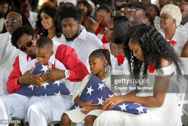 From left, Richard Johnson Sr. Holds La David Johnson Jr., Ah'Leesya Johnson, and Myeshia Johnson, the wife of Army Sgt. La David Johnson during his...