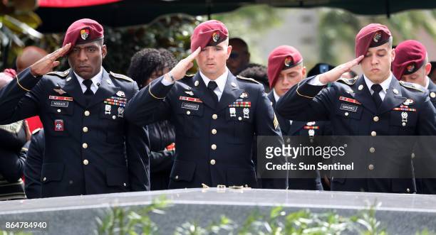 Members of the 3rd Special Forces Group Airborne 2nd Battalion leave pins and salute the casket after the burial of Army Sgt. La David Johnson at...