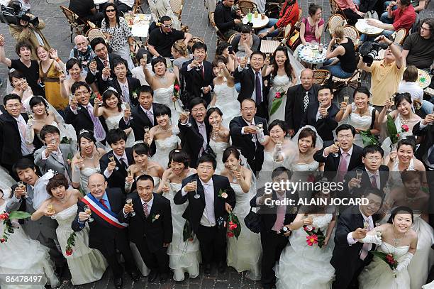 Trente et un couples chinois originaires de la ville de Tianjin et récemment mariés dans leur pays, trinquent le 07 mai 2009 à Tours en compagnie du...