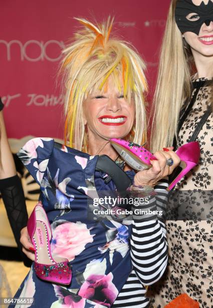 Fashion designer Betsey Johnson poses with her merchandise during an appearance at Macy's at the Fashion Show mall on October 21, 2017 in Las Vegas,...