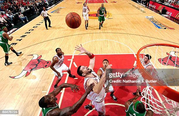 Brad Miller of the Chicago Bulls puts a shot up over Kendrick Perkins and Rajon Rondo of the Boston Celtics in Game Six of the Eastern Conference...