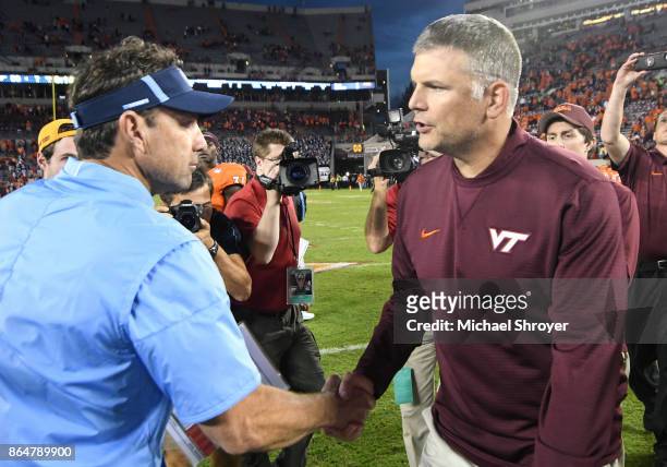 Head coach of the Virginia Tech Hokies Justin Fuente shakes hands with head coach Larry Fedora of the North Carolina Tar Heels following the game at...