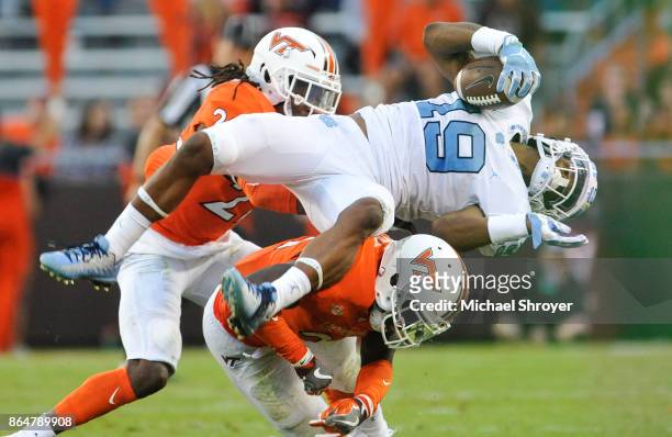 Safety Reggie Floyd of the Virginia Tech Hokies upends wide receiver Dazz Newsome of the North Carolina Tar Heels in the second half at Lane Stadium...