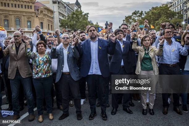 Carles Puigdemont, Catalonia's president, center right, applauds during a demonstration against the Spanish government and the imprisonment of...