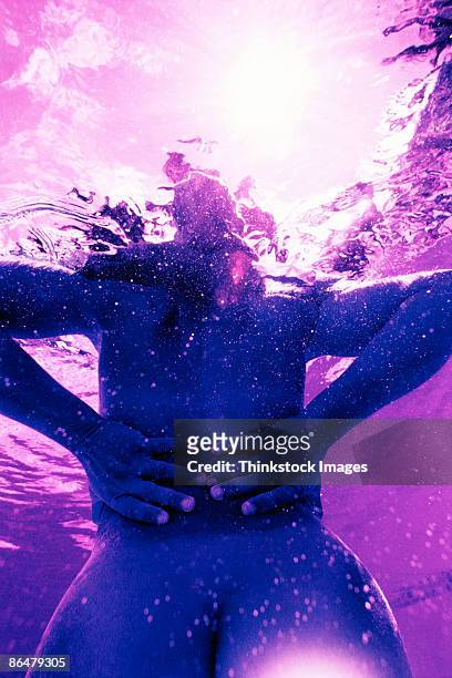 woman underwater with hands on hips - women skinny dipping stockfoto's en -beelden