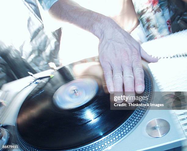 hand spinning record on turntable - dj de club fotografías e imágenes de stock