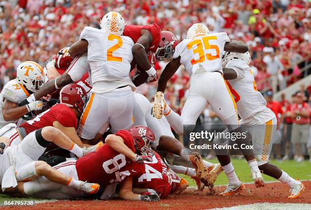 Bo Scarbrough of the Alabama Crimson Tide leaps over Shy Tuttle of the Tennessee Volunteers for a touchdown at Bryant-Denny Stadium on October 21,...