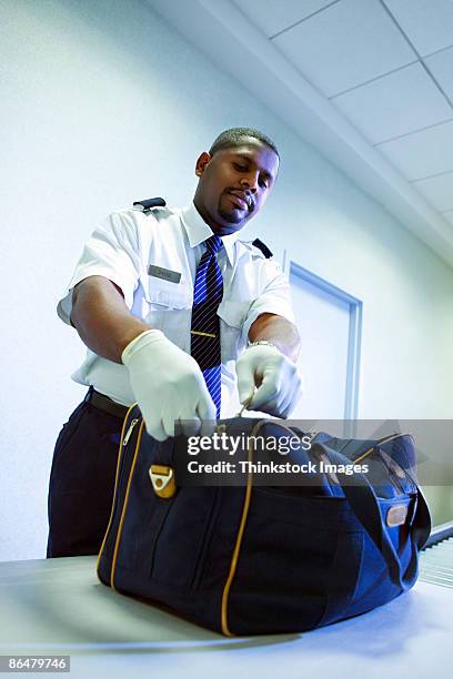 airport security officer searching luggage - border control stock pictures, royalty-free photos & images