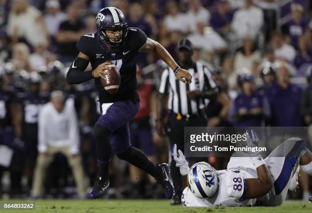 Kenny Hill of the TCU Horned Frogs rolls out and throws a touchdown pass against J.J. Holmes of the Kansas Jayhawks in the first quarter at Amon G....