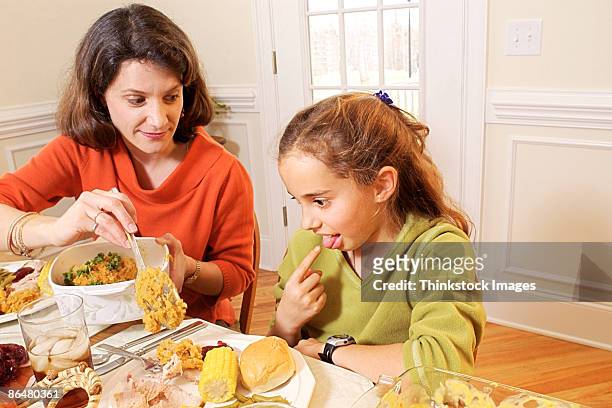 daughter making gagging gesture during thanksgiving meal - angry parent mealtime stock pictures, royalty-free photos & images