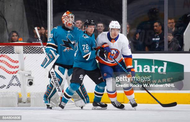 Aaron Dell and Tim Heed of the harks defend the net against Nikolay Kulemin of the New York Islanders at SAP Center on October 14, 2017 in San Jose,...