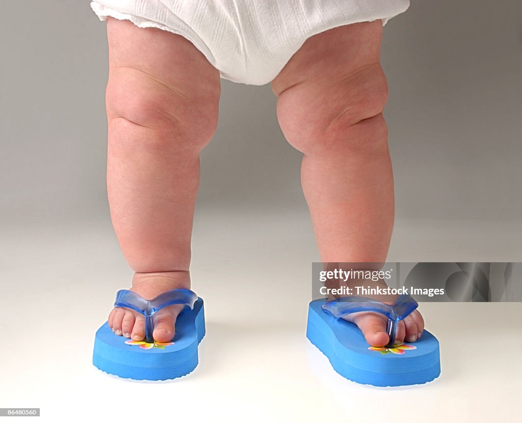 Legs of baby wearing flip-flops