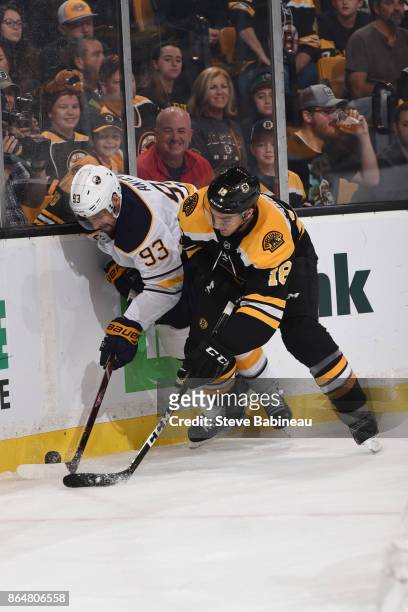 Kenny Agostino of the Boston Bruins fights for the puck against Victor Antipin of the Buffalo Sabres at the TD Garden on October 21, 2017 in Boston,...