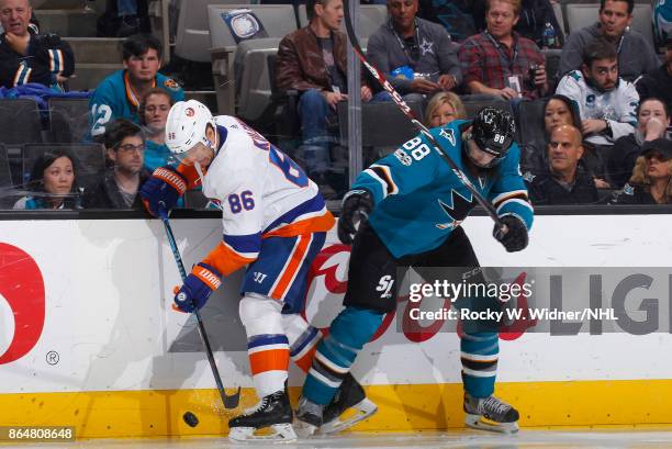 Nikolay Kulemin of the New York Islanders skates after the puck against Brent Burns of the San Jose Sharks at SAP Center on October 14, 2017 in San...