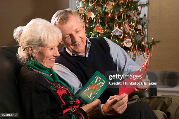 couple reading christmas cards - man reading card stock pictures, royalty-free photos & images