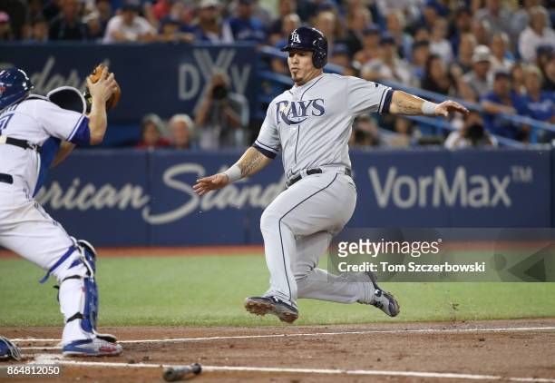 Wilson Ramos of the Tampa Bay Rays slides into home plate before he is tagged out by Miguel Montero of the Toronto Blue Jays in the second inning...