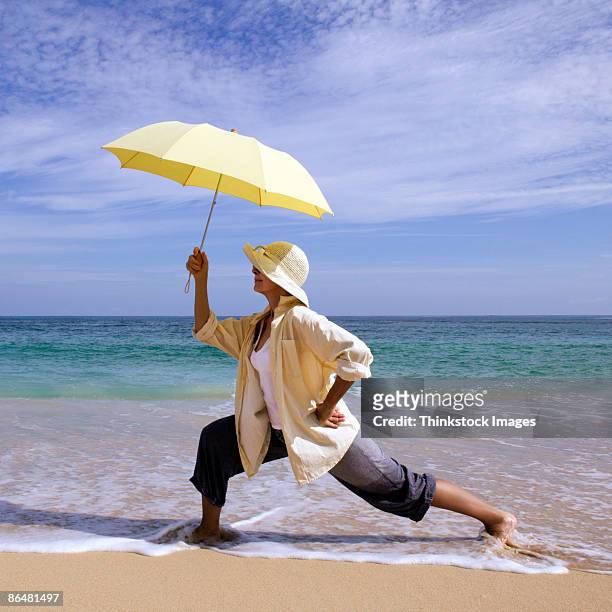 woman with umbrella at beach - life si a beach stock pictures, royalty-free photos & images