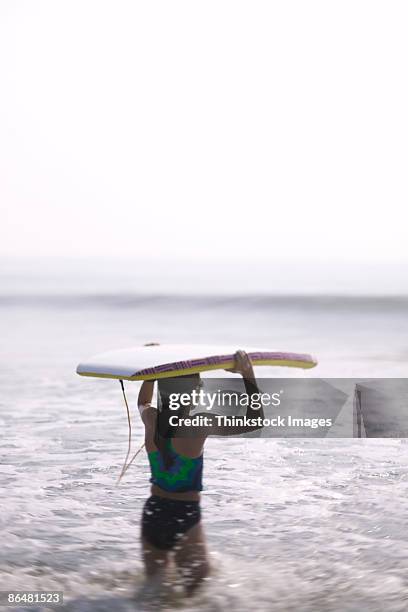 girl in ocean with boogie board - life si a beach stock pictures, royalty-free photos & images