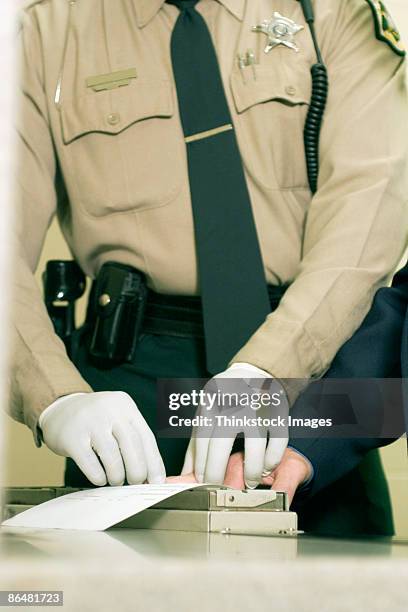 police officer fingerprinting person - prison uniform stock pictures, royalty-free photos & images