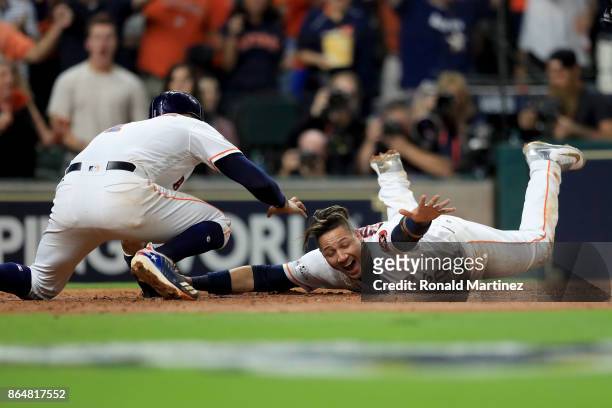 Yuli Gurriel of the Houston Astros slides safe at home plate against Gary Sanchez of the New York Yankees off of a double hit by Brian McCann against...