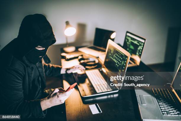 computer-hacker mit telefon - white collar crime stock-fotos und bilder