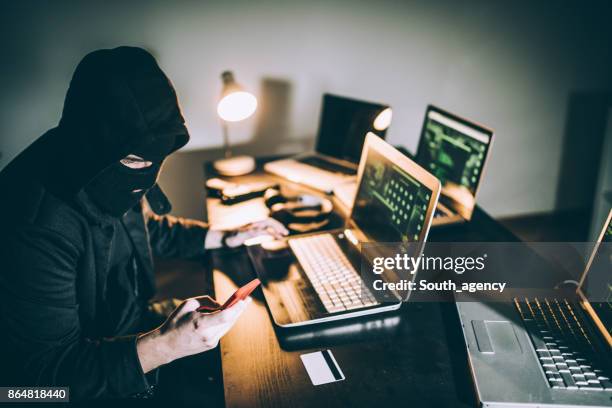 computer hacker met behulp van de telefoon - diefstal criminaliteit stockfoto's en -beelden