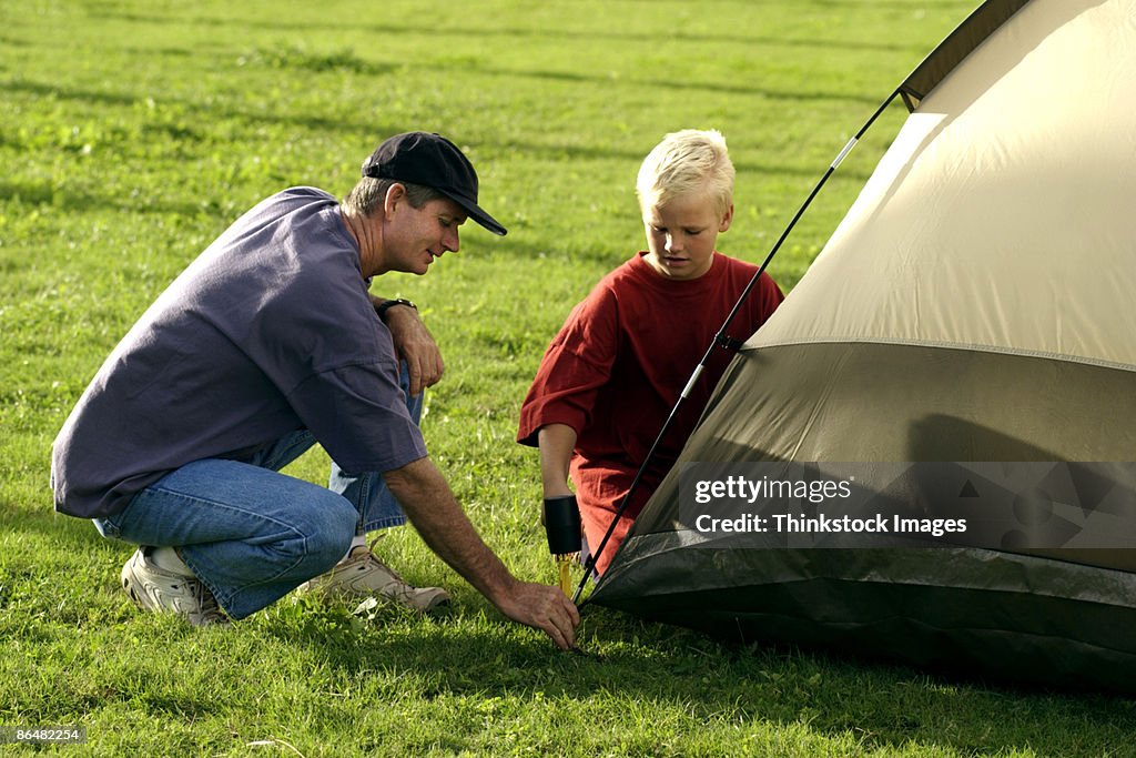 Father and son setting up tent