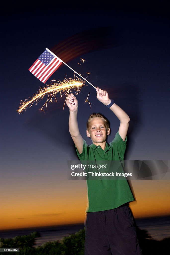 Boy with American flag and sparkler