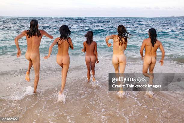 nude people running into ocean - bare bottom 個照片及圖片檔