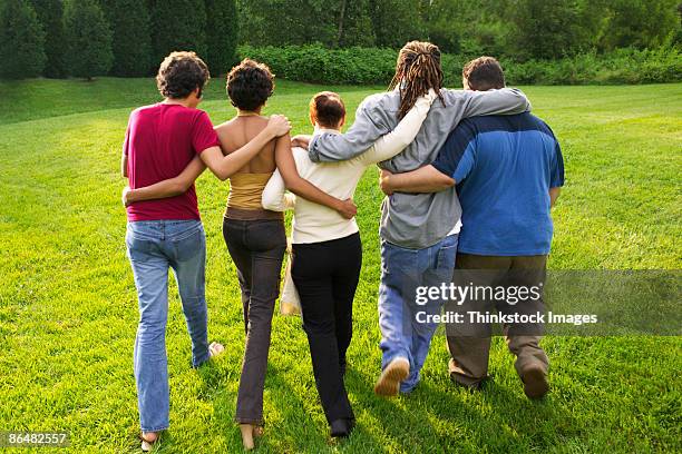 friends walking together outdoors - braços dados imagens e fotografias de stock